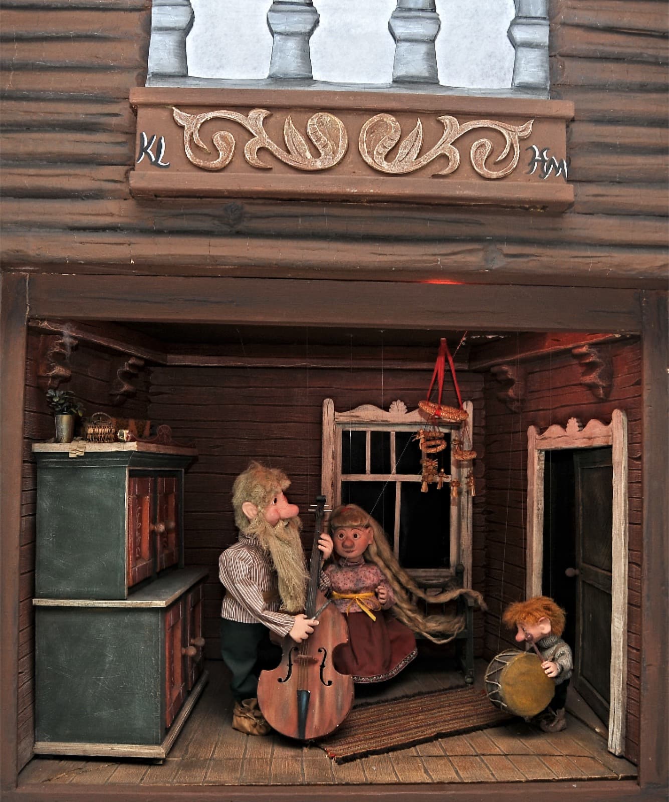 Miniatur-Diorama: Cellospieler in einer Holzstube